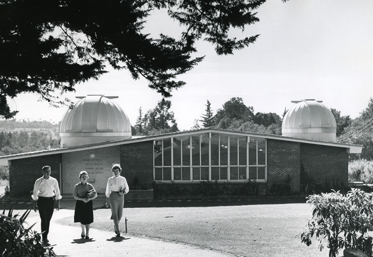 三个学生走在卡罗尔天文台前.